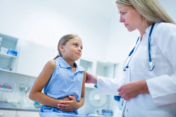 Girl with doctor clutching stomach
