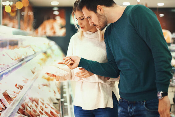 Couple buying fresh meat in supermarket