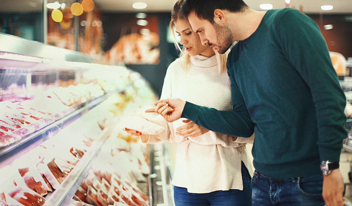 Couple buying fresh meat in supermarket