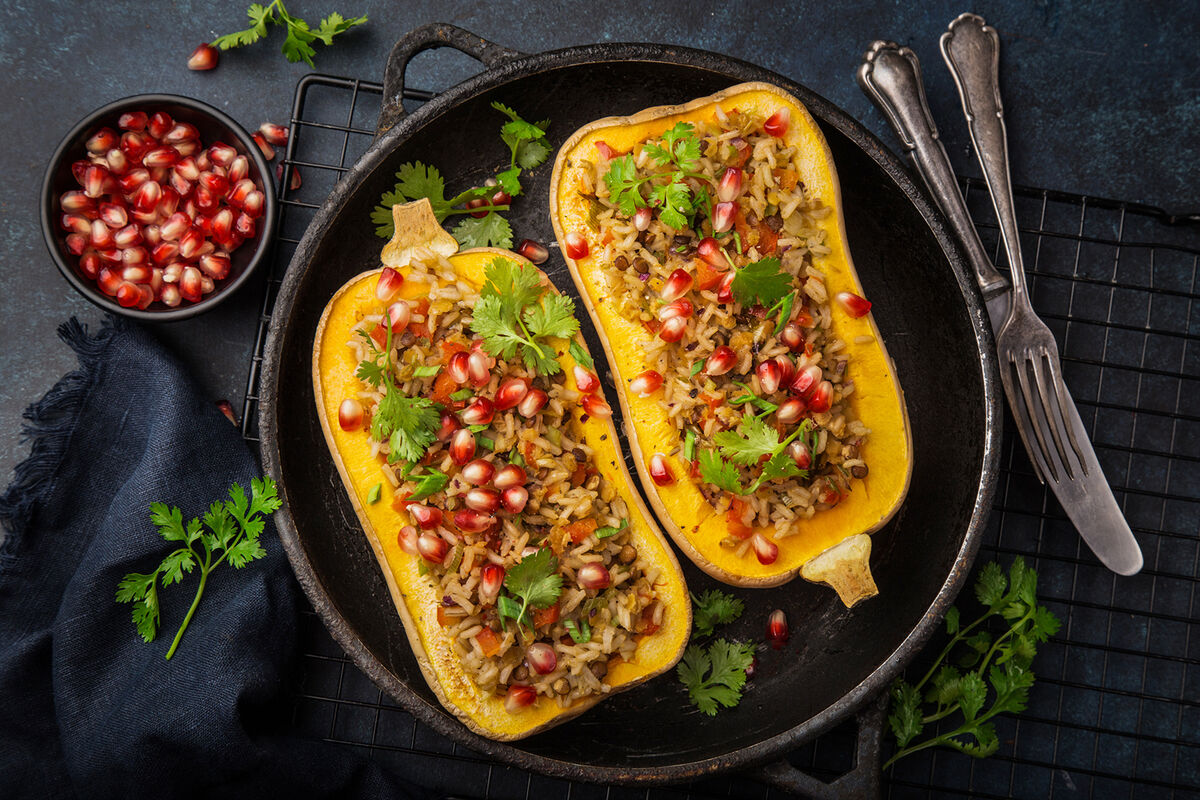 Butternut squash stuffed with brown rice and vegetables, served with pomegranate and coriander