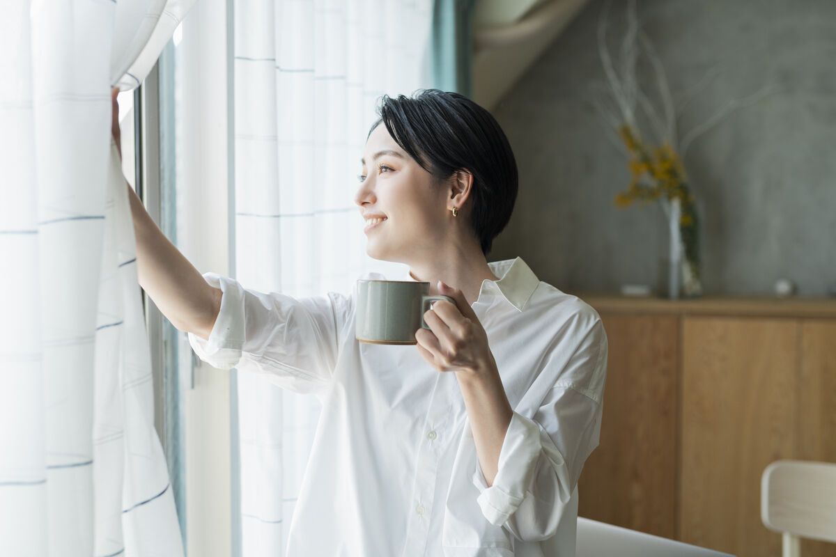 woman drinking coffee looking out the window