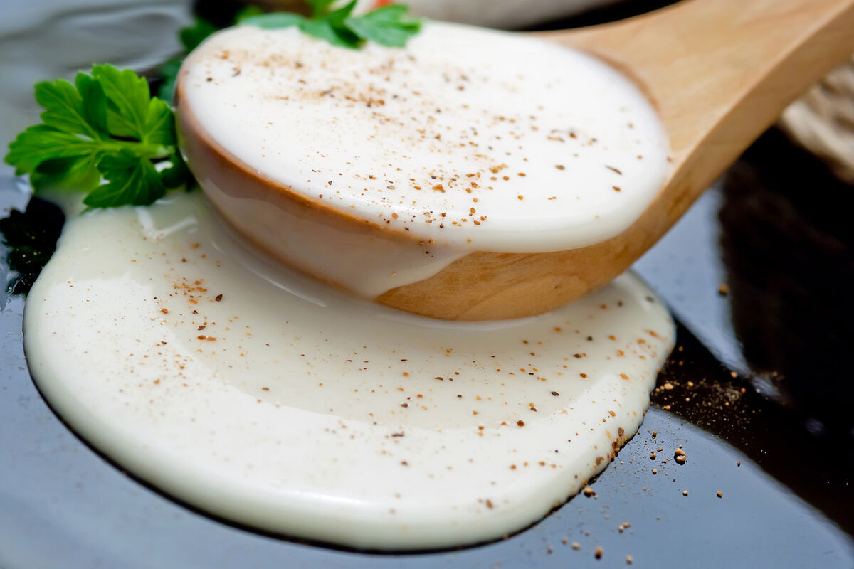 Bechamel sauce in a wooden spoon