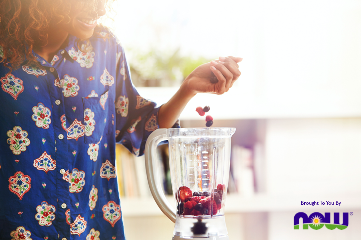 woman making a berry smoothie