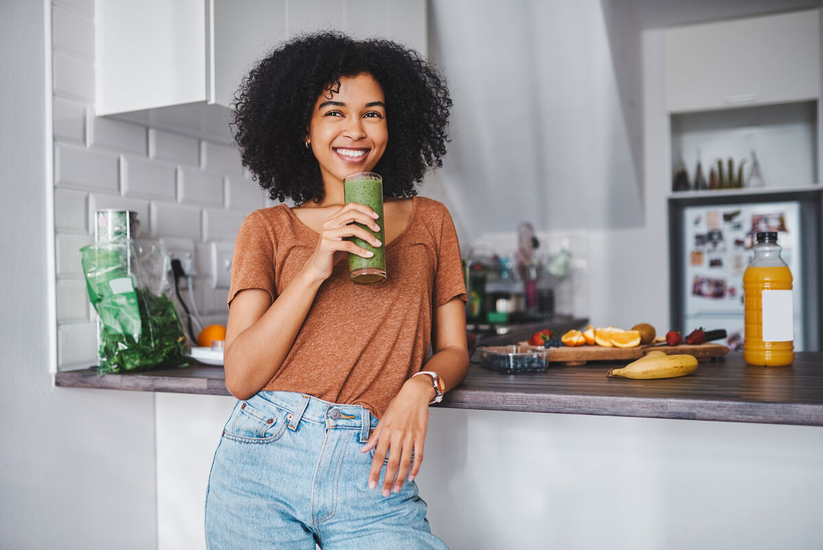 happy woman drinking a green smoothie