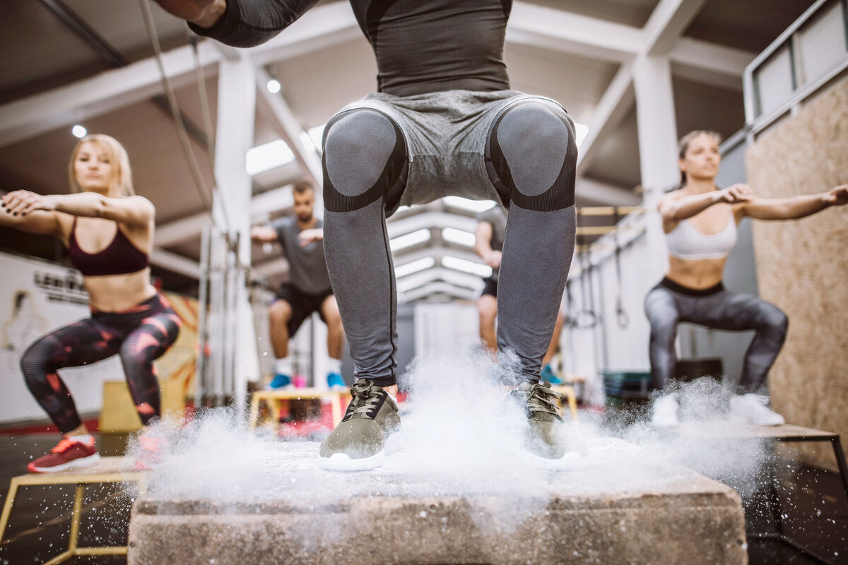 People Doing Box Jumps In Gym