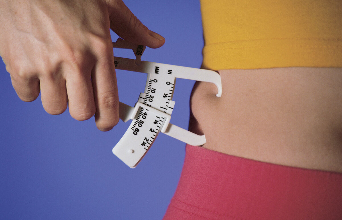 Woman measuring fat on waist