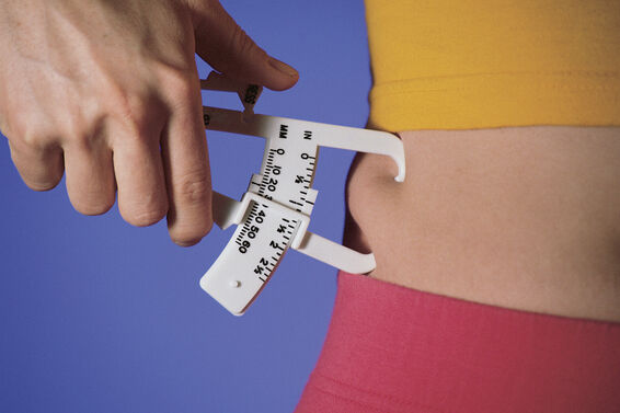Woman measuring fat on waist