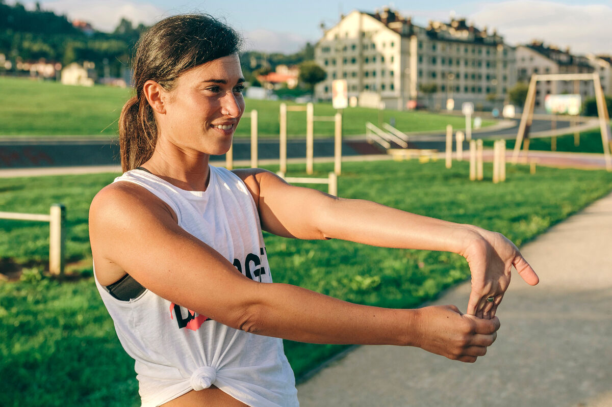 Woman doing wrist exercise in park