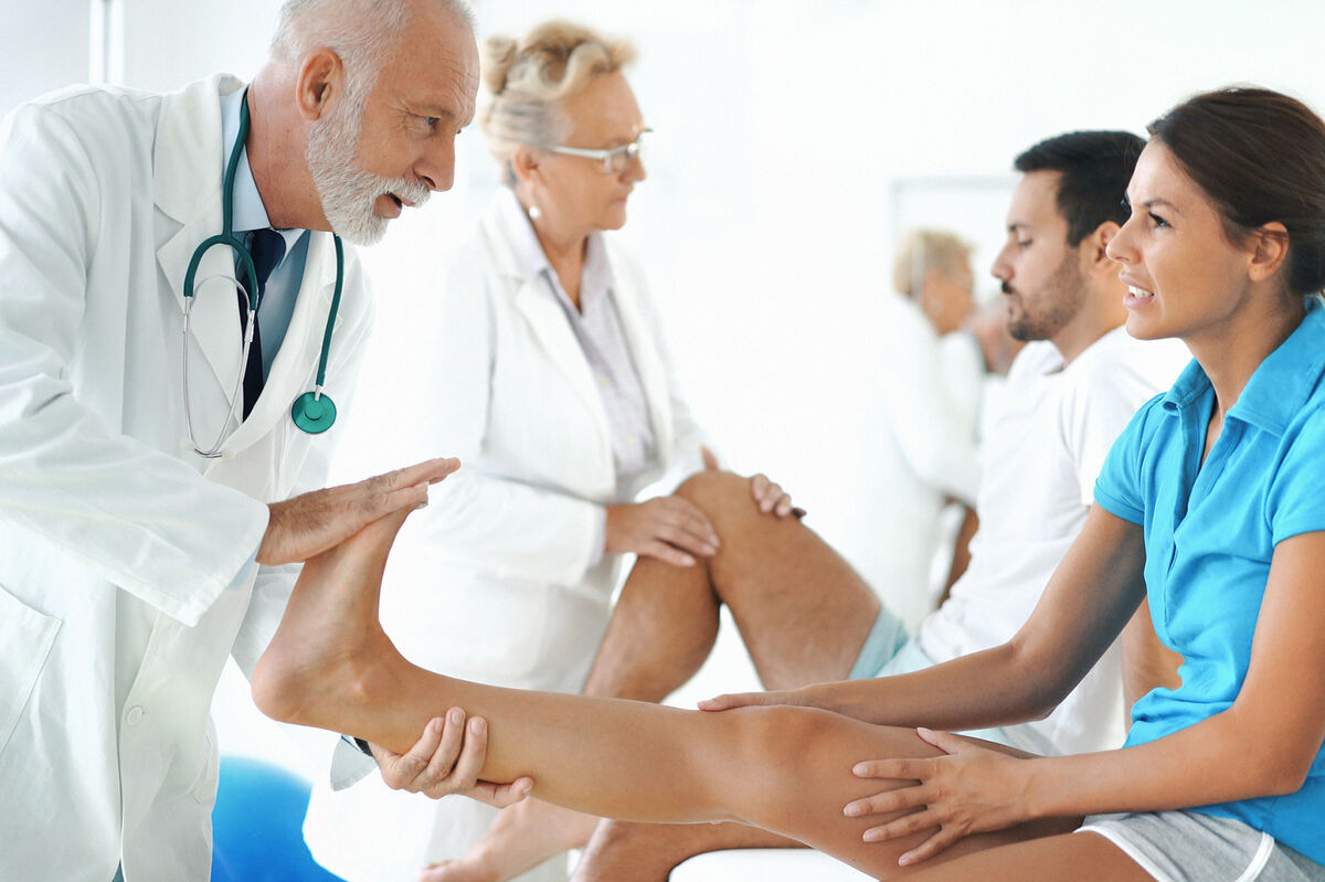 Doctor stretching woman's ankle