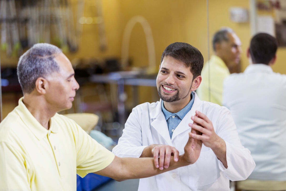 Doctor helps patience with his wrist