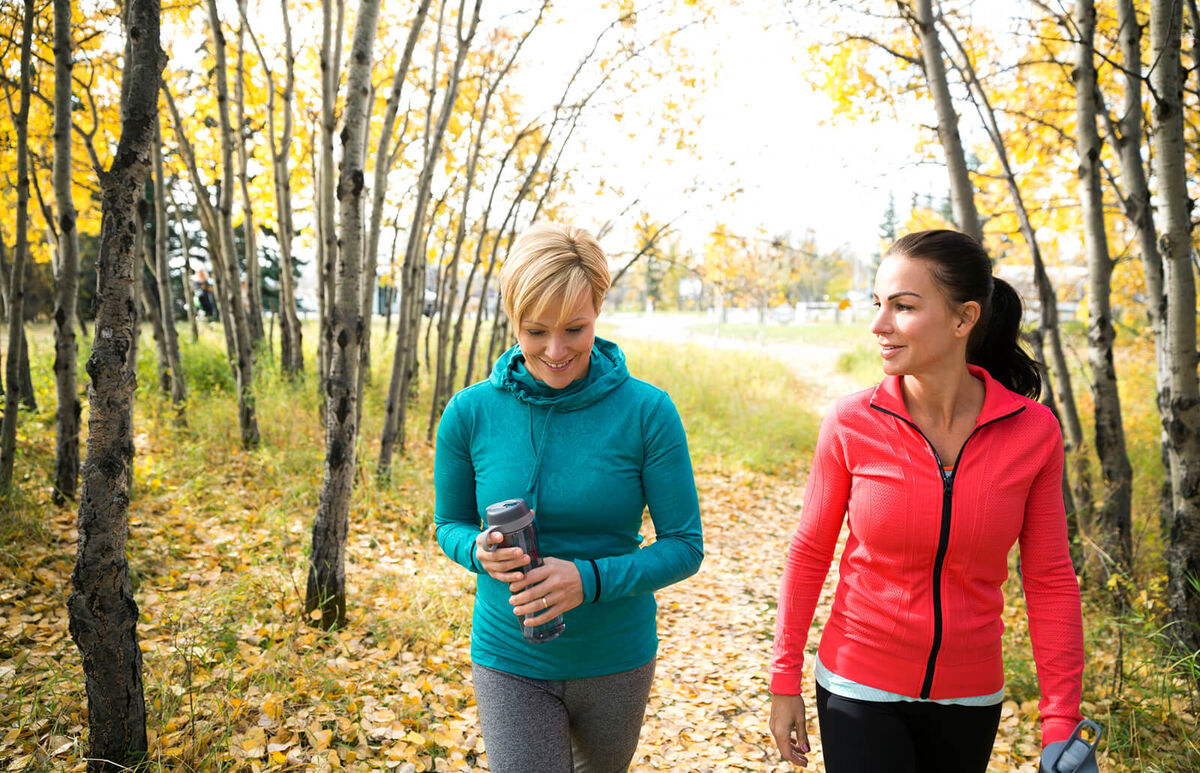 Friends walking on path in autumn park