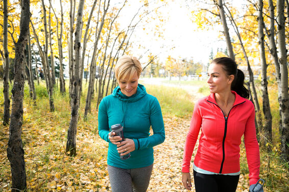 Friends walking on path in autumn park