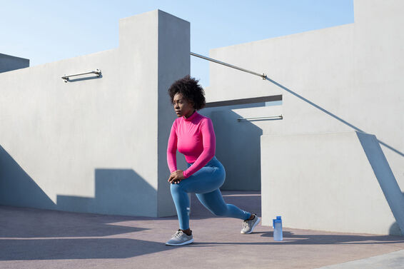 sportswoman lunging on sunny day