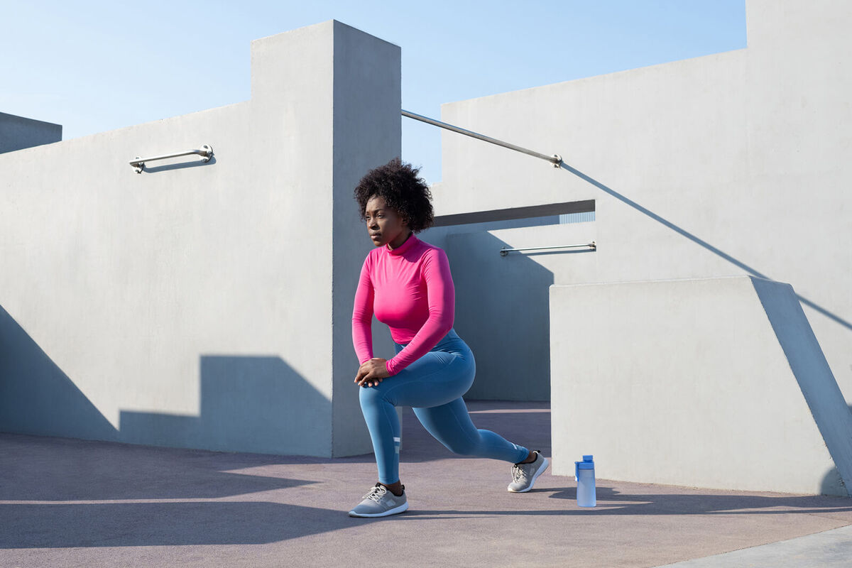 sportswoman lunging on sunny day