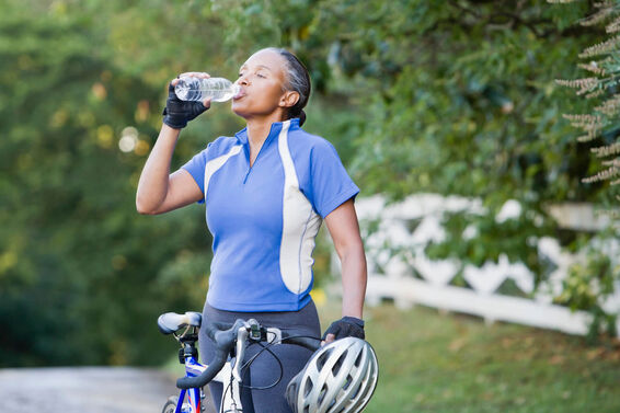Senior female cyclist drinking water