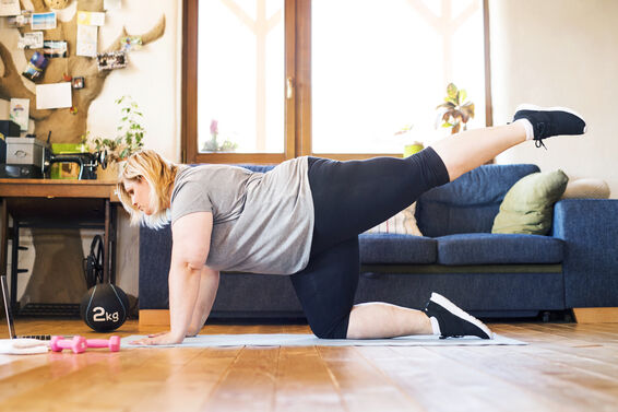 Overweight woman at home working out