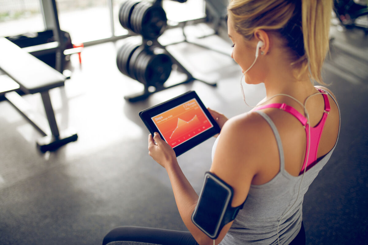 Tracking her progress with fitness app on digital tablet