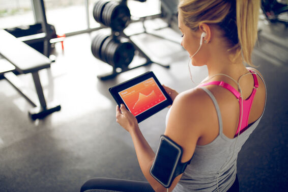 Tracking her progress with fitness app on digital tablet