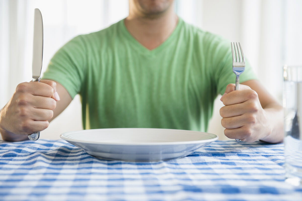 man holding fork and knife
