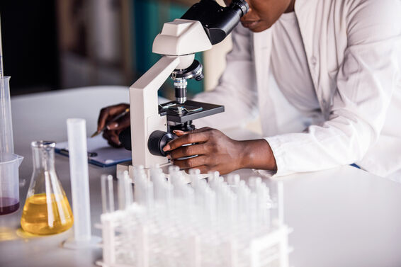Female scientist adjusting focus while looking at a sample through the microscope