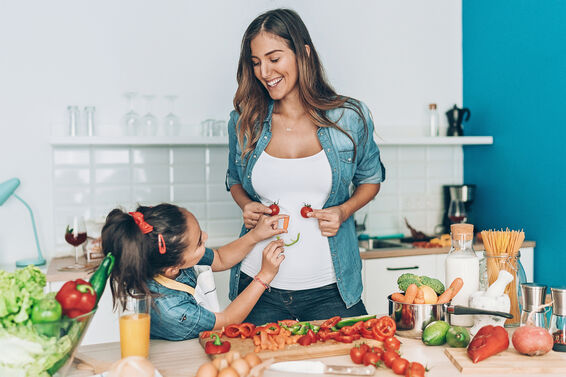 mother and daughter making vegetable smiley face