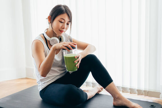 Woman Drinking Green Smoothie After Yoga