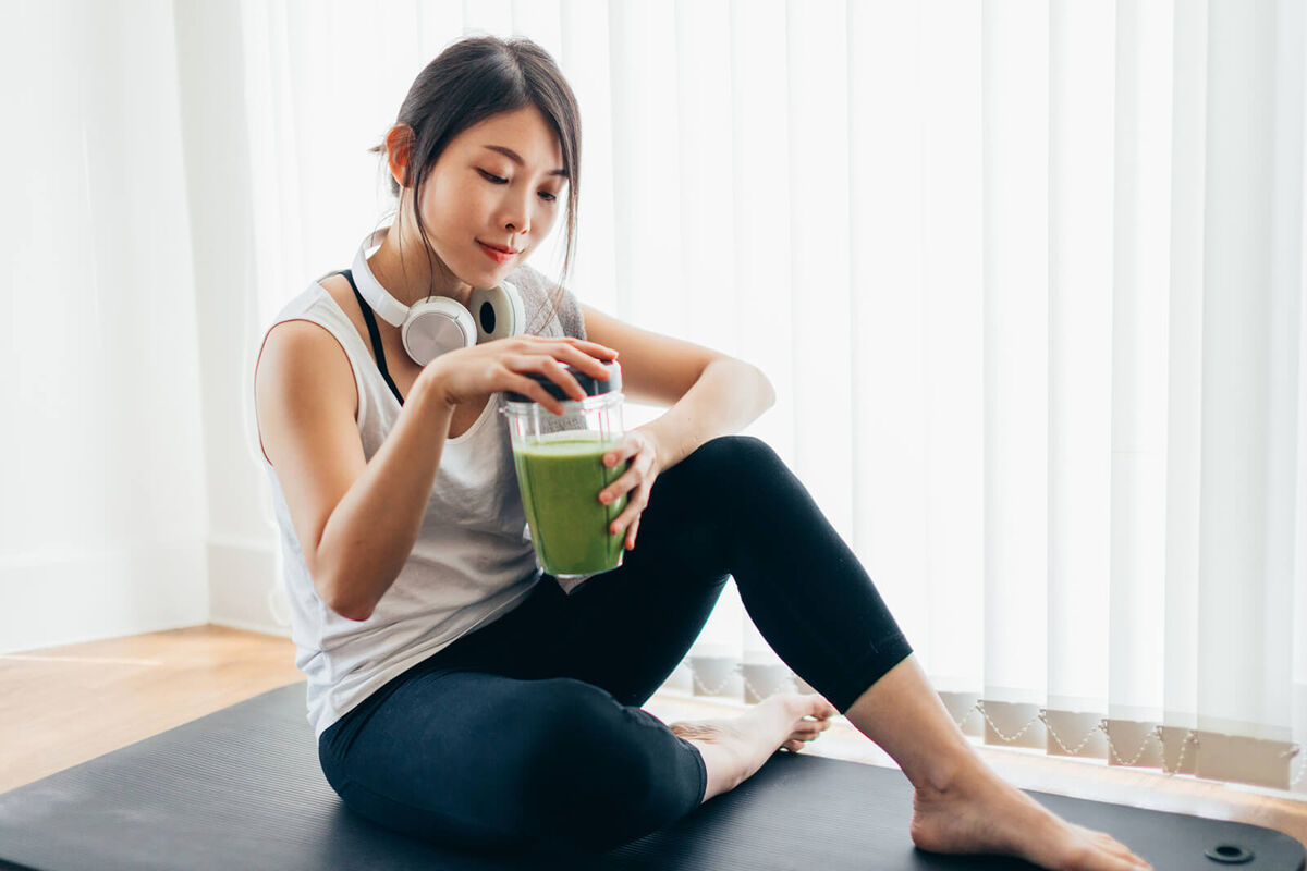 Woman Drinking Green Smoothie After Yoga