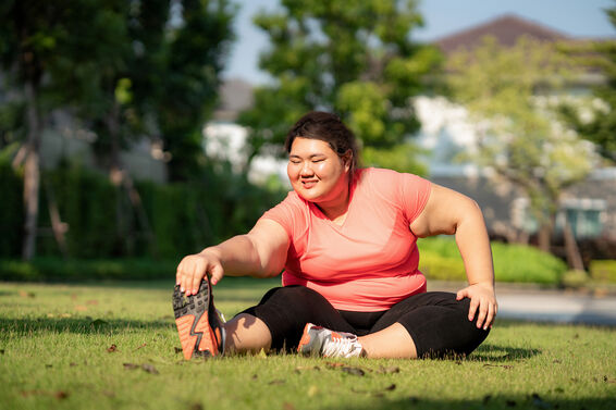 Overweight woman exercising in park, happy and smile in morning during sunlight