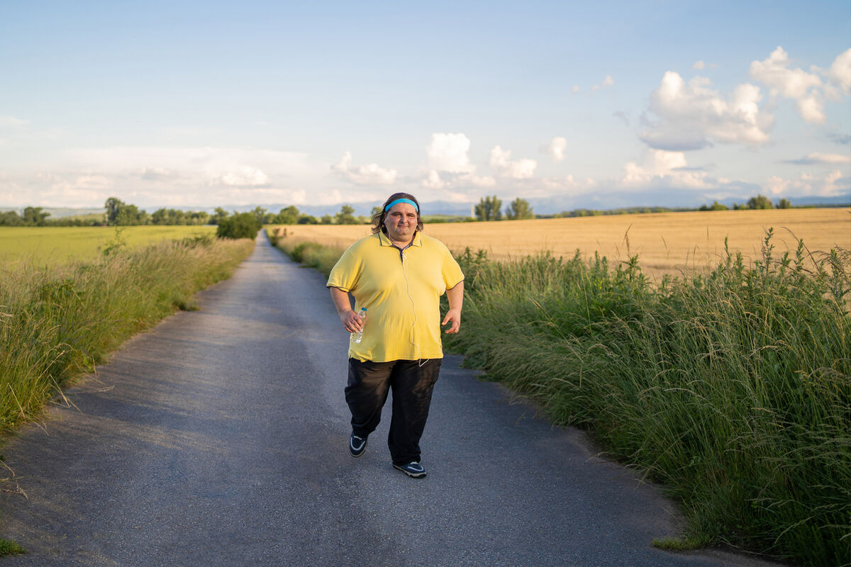 A large build man jogging on empty road