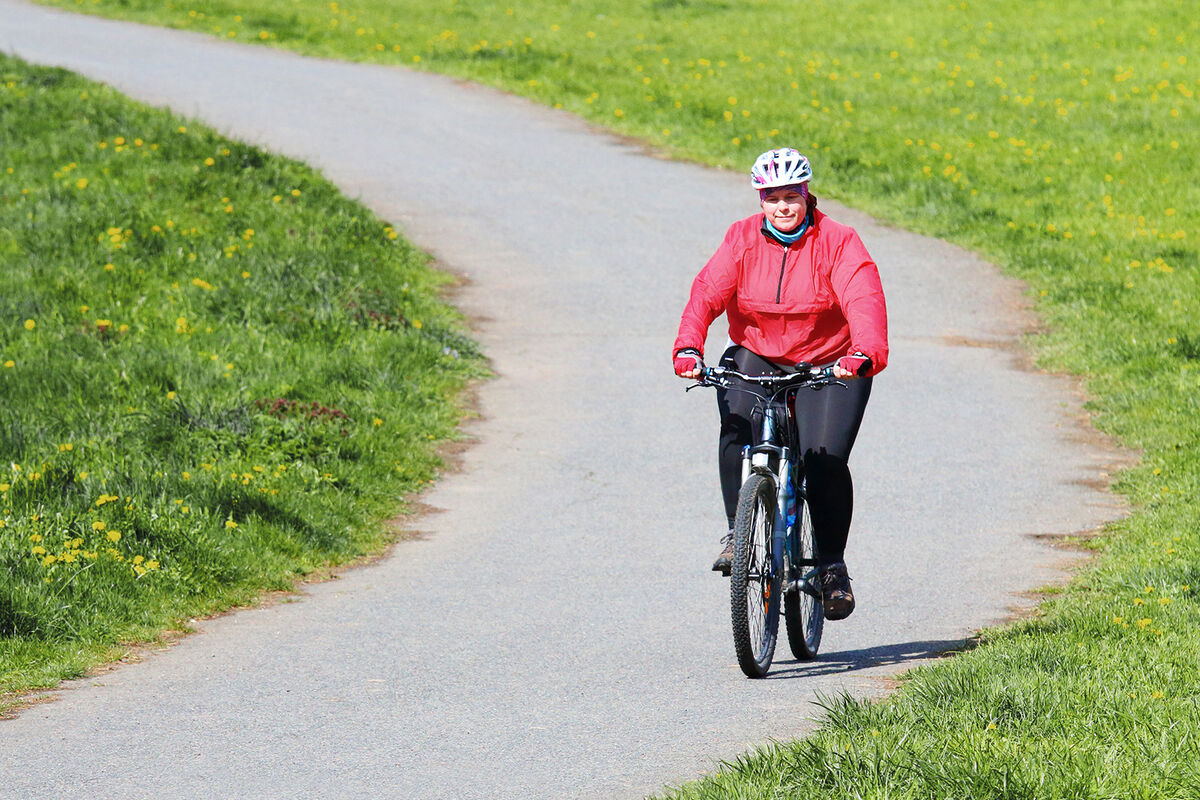 Overweight woman riding on bicycle.