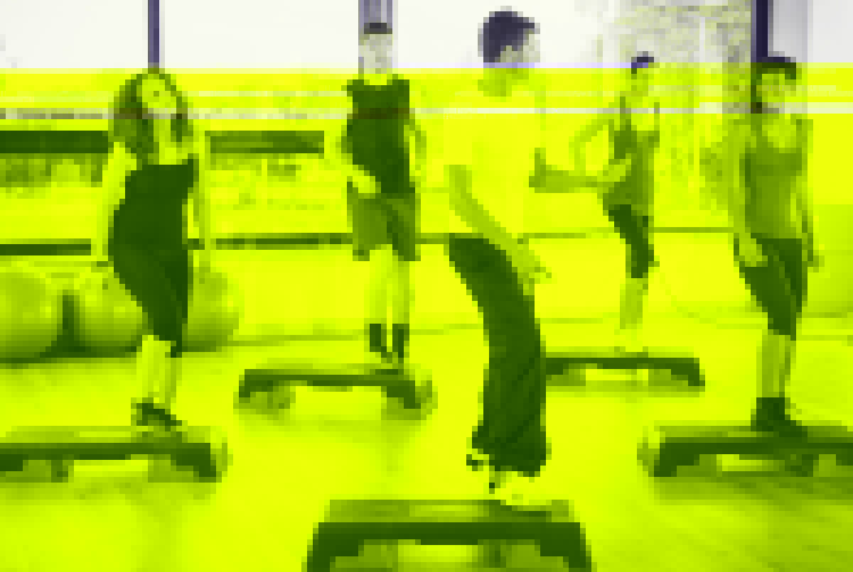 Group of people doing Step aerobics in the gym