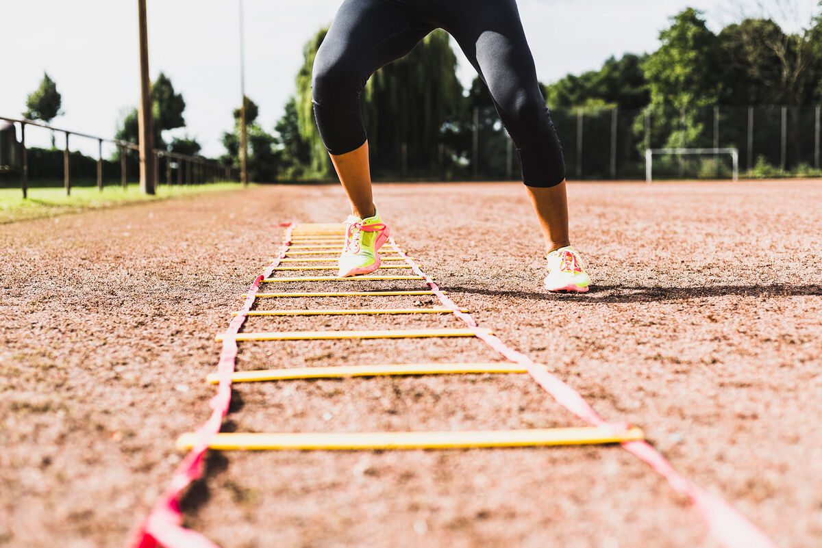 Woman exercising with agility ladder