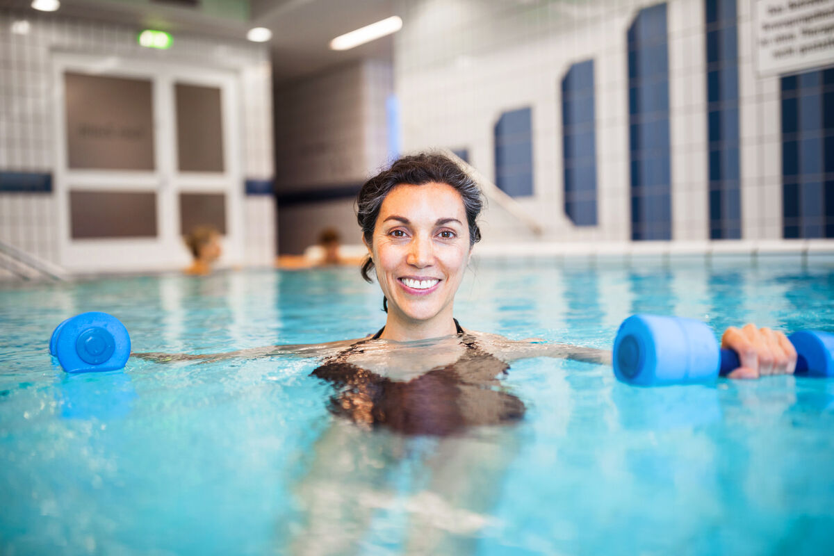 Woman exercising with dumbbells in swimming pool
