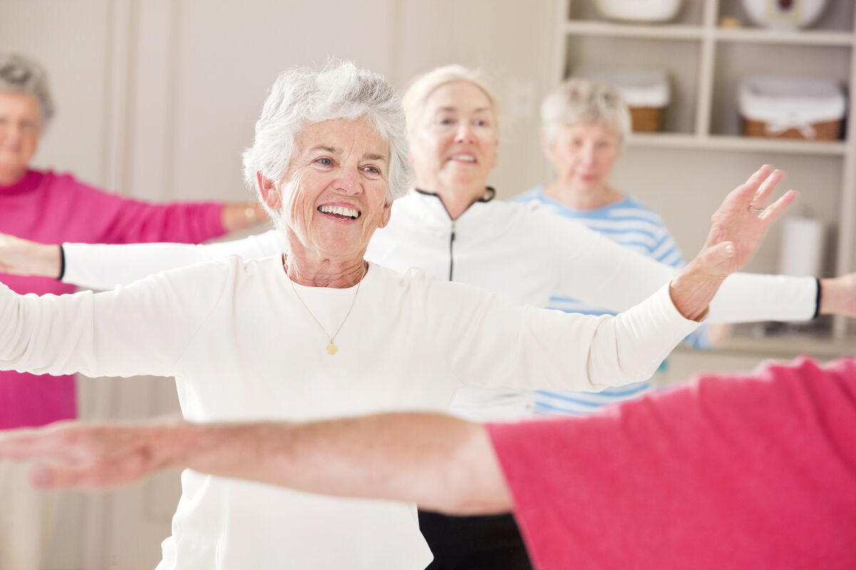 Seniors doing arm strengthening exercises in a health club