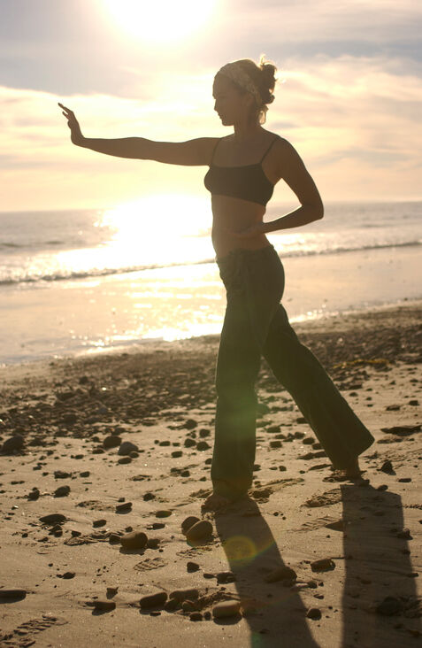 woman practicing yoga on beach