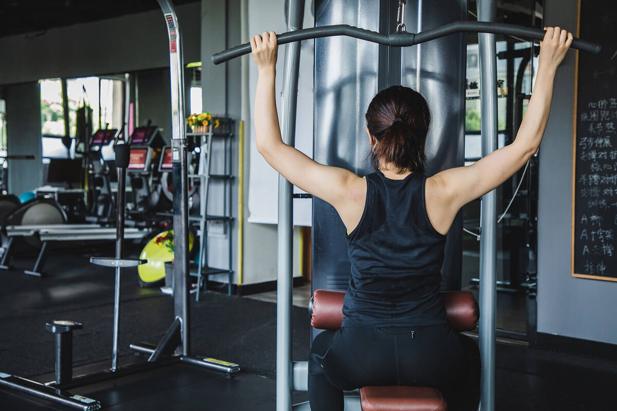 woman doing lat pulldown in a gym