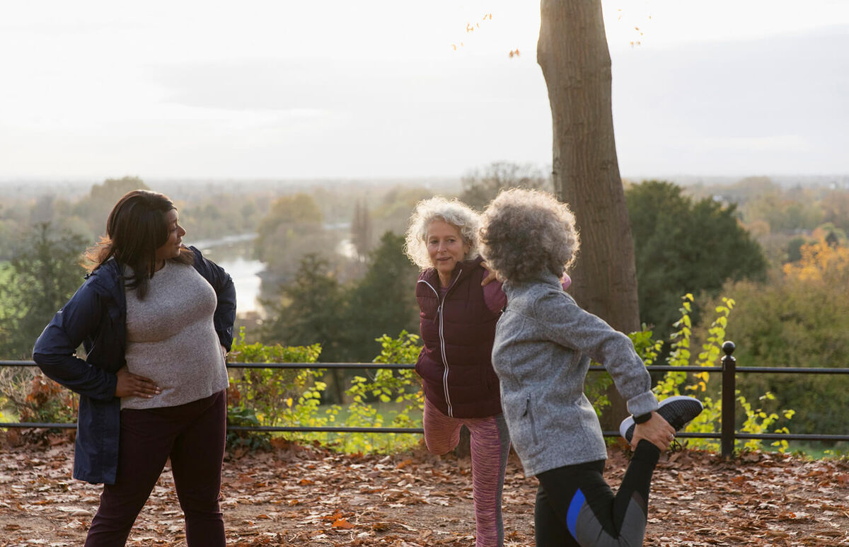 Active senior women friends stretching legs
