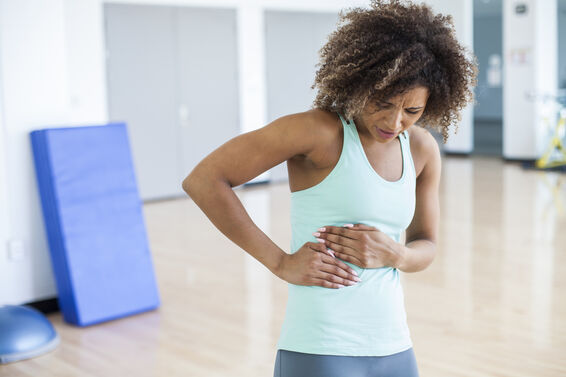 woman with stomach cramp while exercising