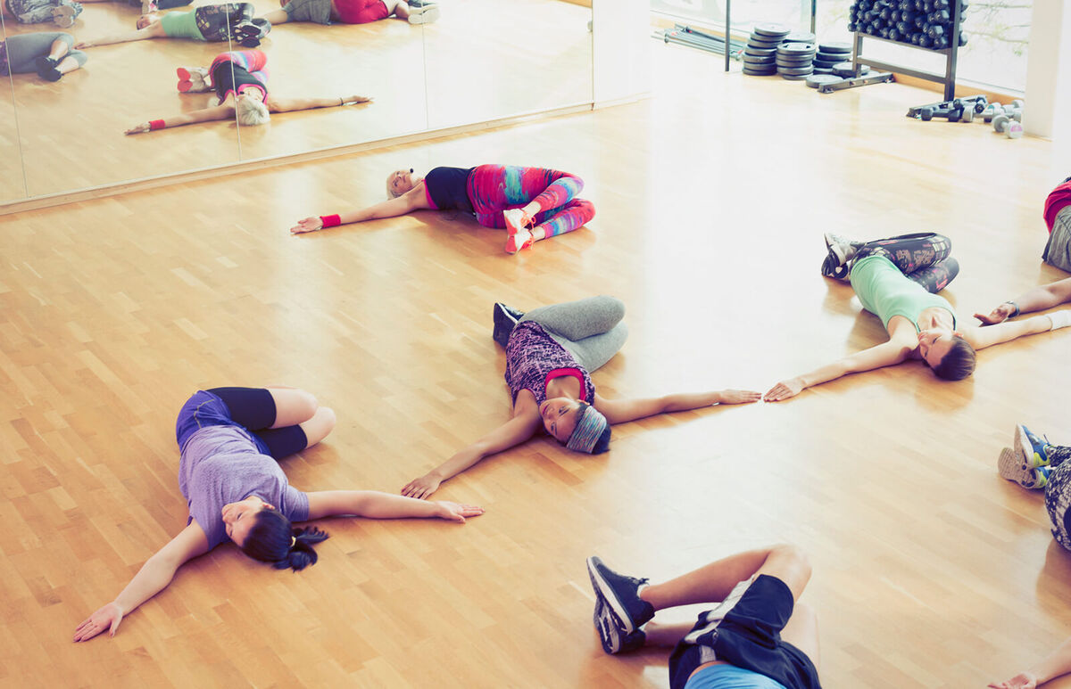 Exercise class doing twisted stretch in studio