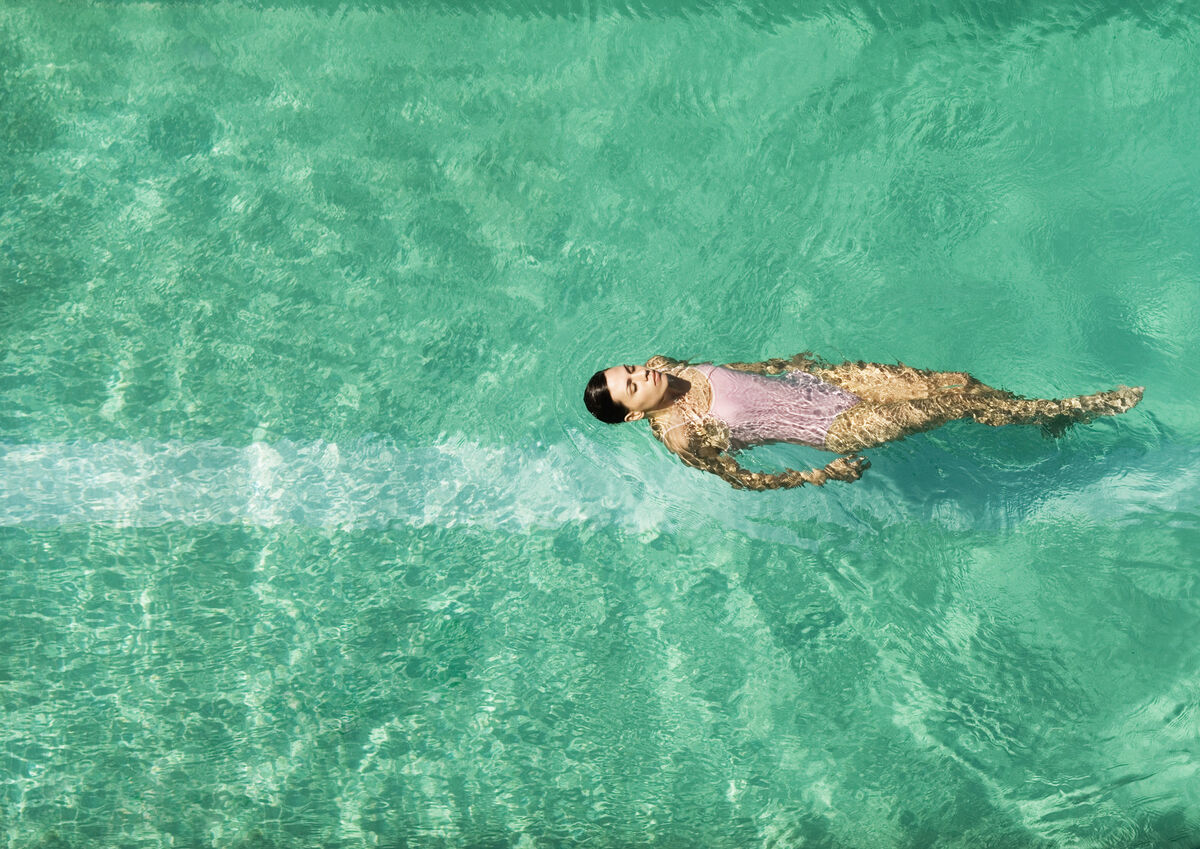 Overhead of woman floating in a pool