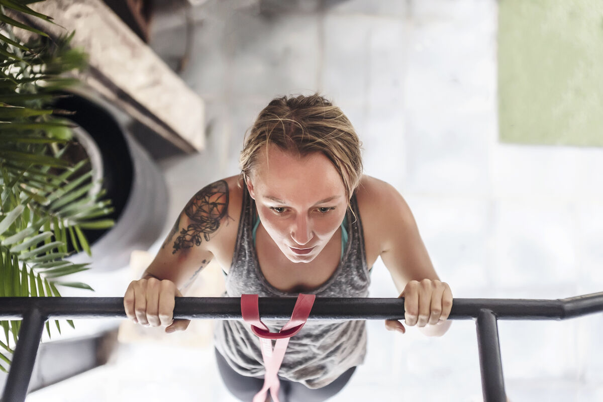 woman doing pull-ups at gym