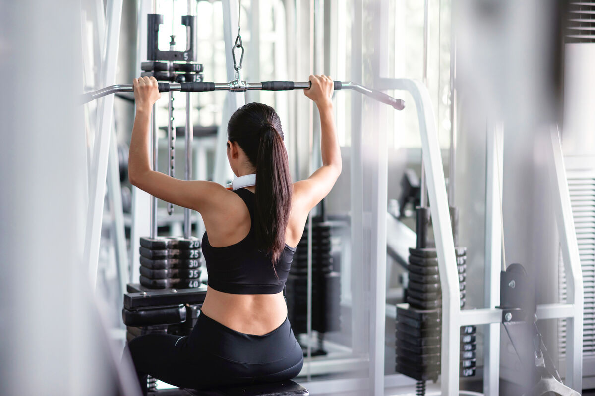 Woman exercise with lat pulldown machine in gym