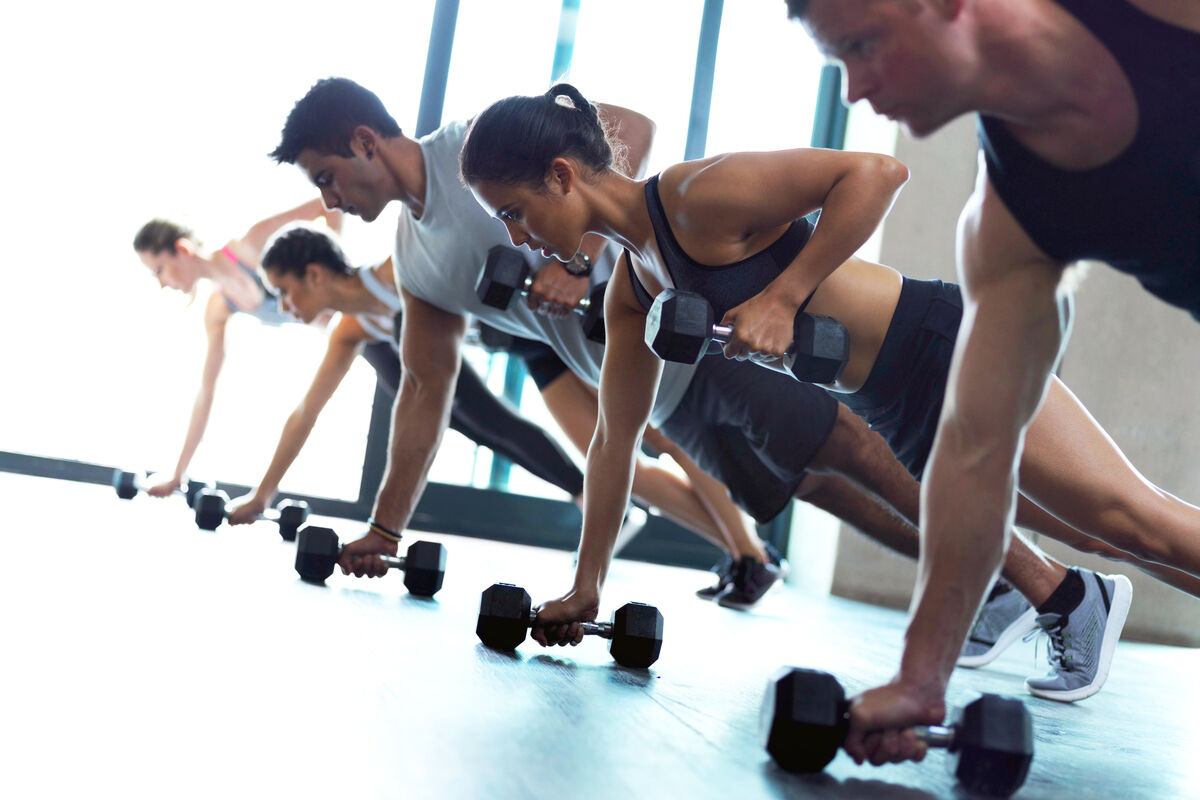 Fitness group working out with dumbbells in a gym