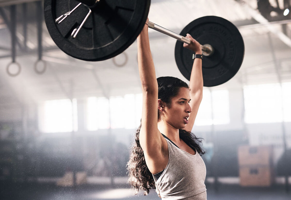 Woman lifting a barbell in a gym