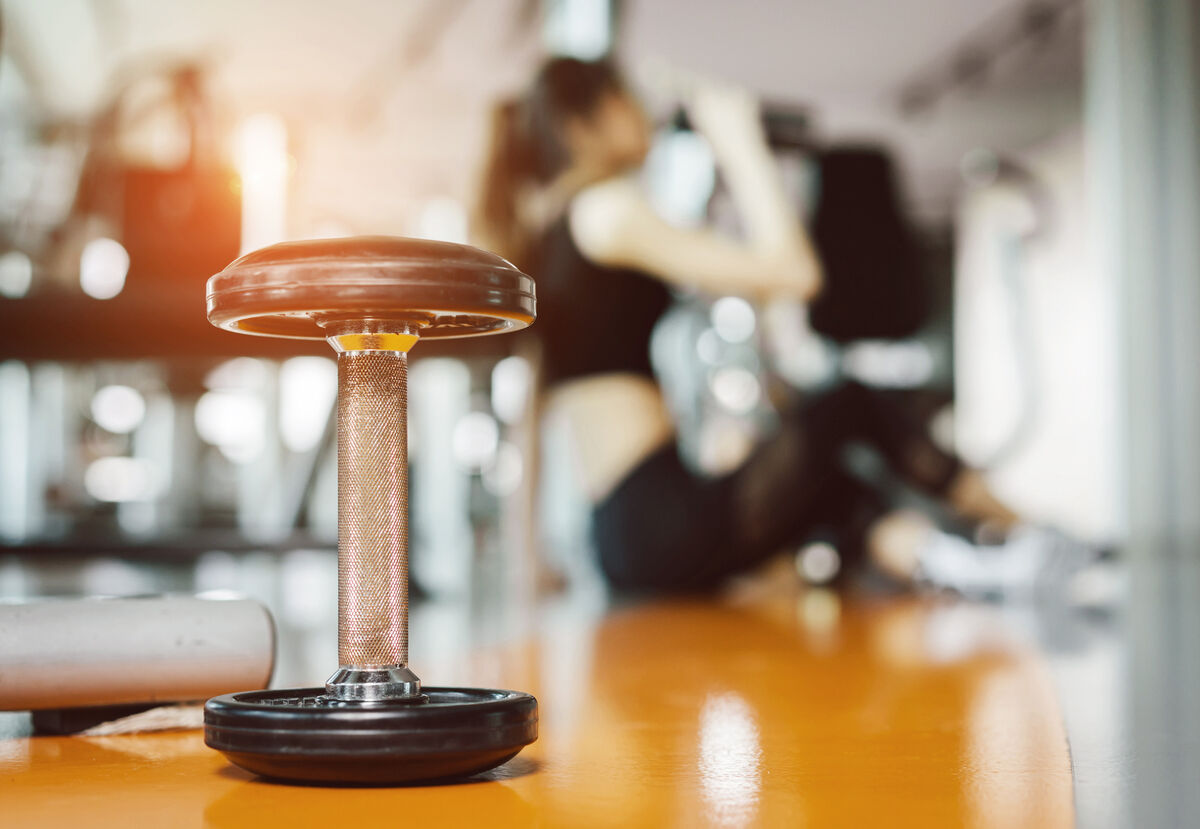 Dumbbell With Woman Sitting In Background