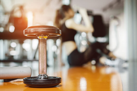 Dumbbell With Woman Sitting In Background