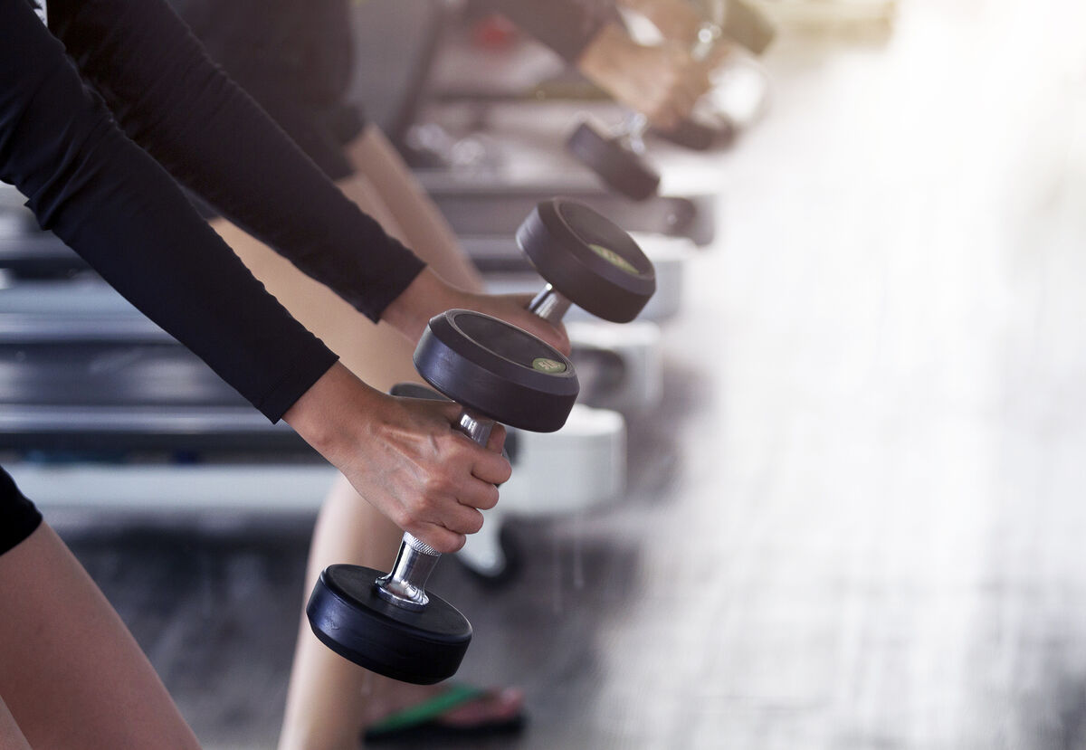 Female workout weight training with dumbbell at gym