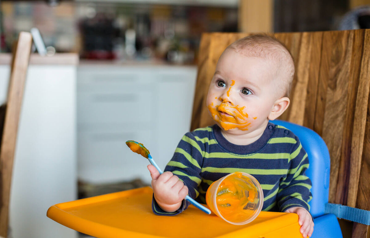 Baby boy eating mashed food
