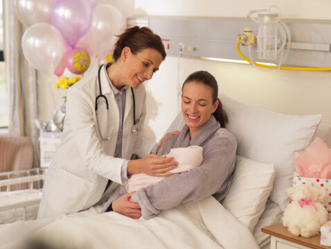 Doctor with woman holding newborn baby