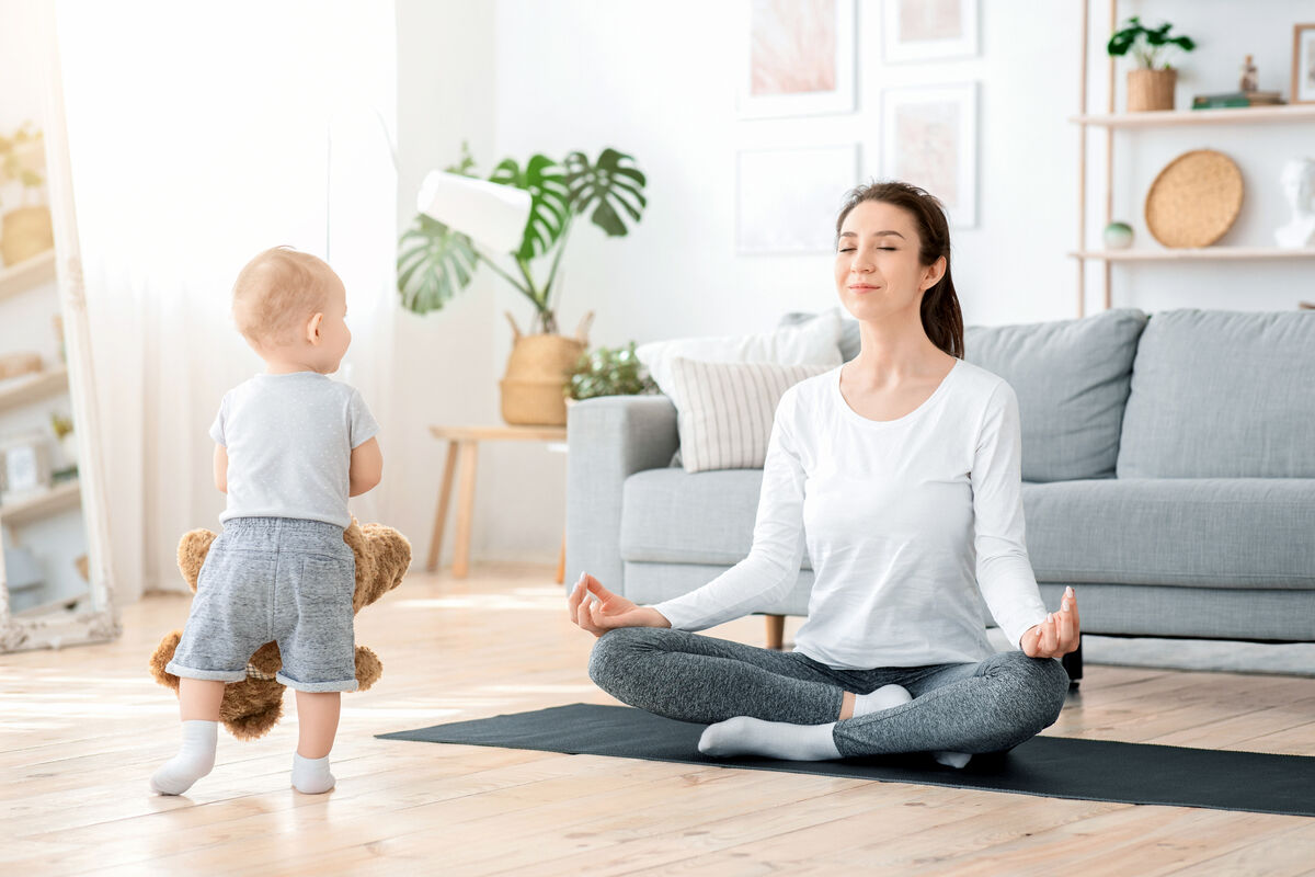 Mom Meditating With Cute Toddler Baby Around